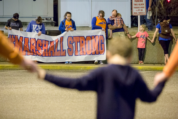 People holding hands at a vigil outside at Marshall County High School