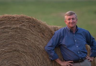 George Wood stands by a hay bale
