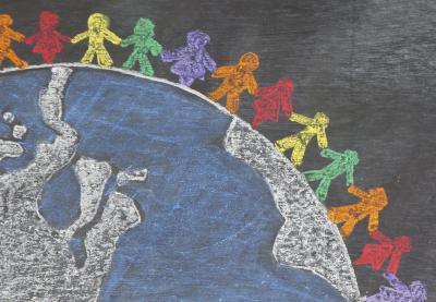 chalkboard drawing of multicolored stick people standing on globe