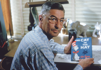 Theodore Seuss Geisel, also known as Dr. Seuss, holding a copy of his book 'The Cat in the Hat'