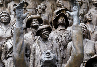 Statues depicting emancipated enslaved people celebrating and looking towards the sky.