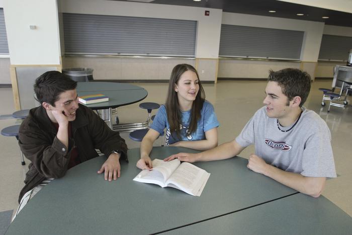 Columbine's students sitting with open book at the school's food court