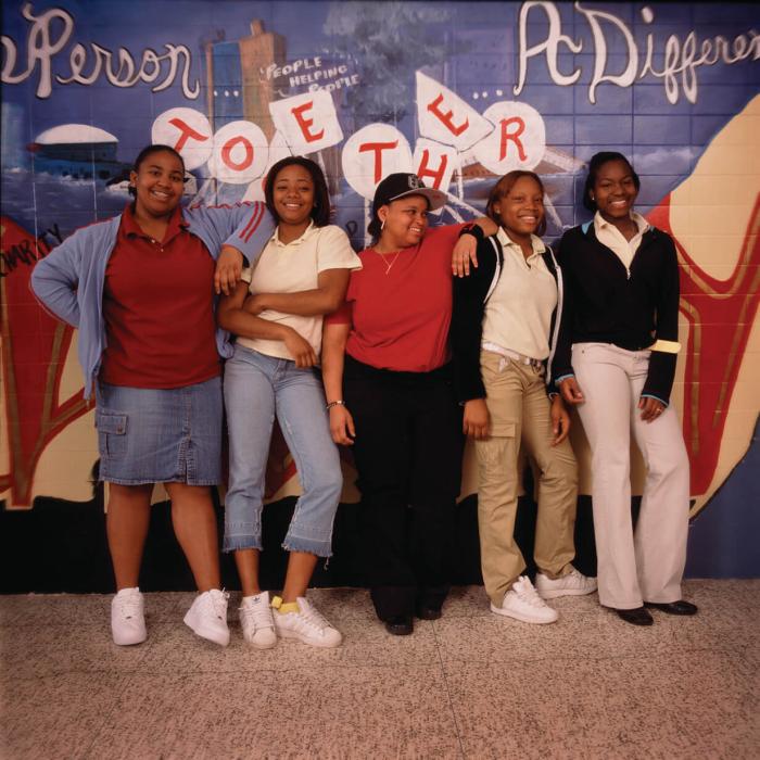 5 students standing in front of the 'unity mural'