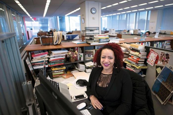 Nikole Hannah Jones sitting at her desk, covered in books and notes