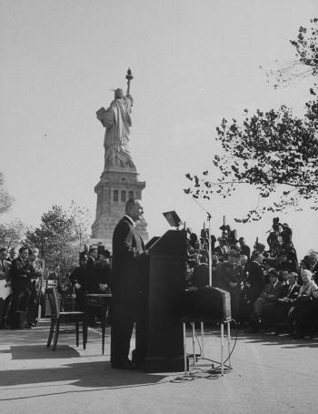 President Lyndon B. Johnson signing immigration reform under Statue of Liberty