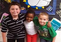 3 young students from different racial hugging and smilling 