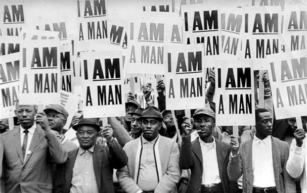 Sanitation workers hold protest signs that say, "I am a man." 
