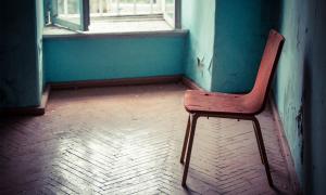 Empty old chair sitting in abandoned hallway