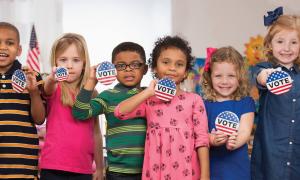 students holding vote buttons