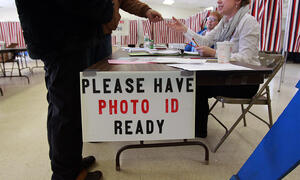 Voter handing photo identification to polling official.