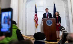 Ralph and Pam Northam behind a podium at a press conference.