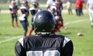 A football player in a uniform with their back to the viewer.