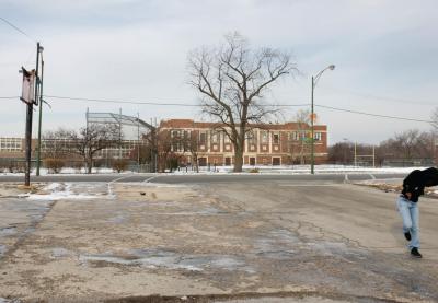 Student running on the desert snowed roads in front a public school in Chicago