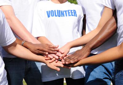 Volunteers put their hands together in solidarity.