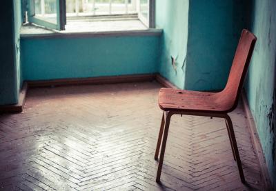 Empty old chair sitting in abandoned hallway