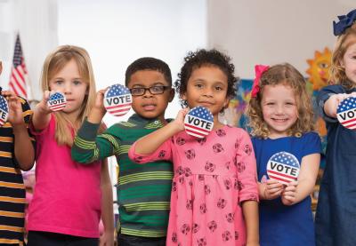 students holding vote buttons