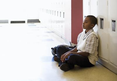 Young African-American Child Sitting Against Locker