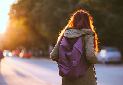 Student with long hair and purple book bag on.