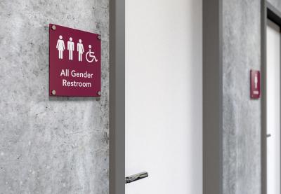 Sign that reads "All Gender Restroom" next to restroom door.
