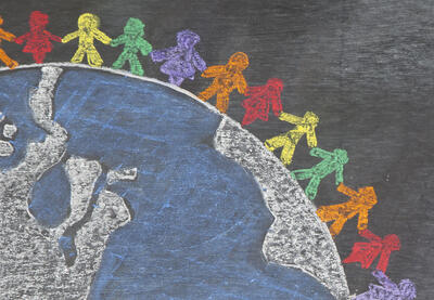 Children drawn in chalk holding hands around the globe