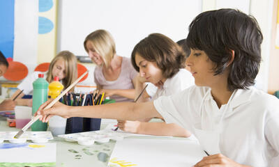 boy painting with classmates