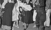  Japanese Americans exit a bus in professional attire. Two women hold babies. 