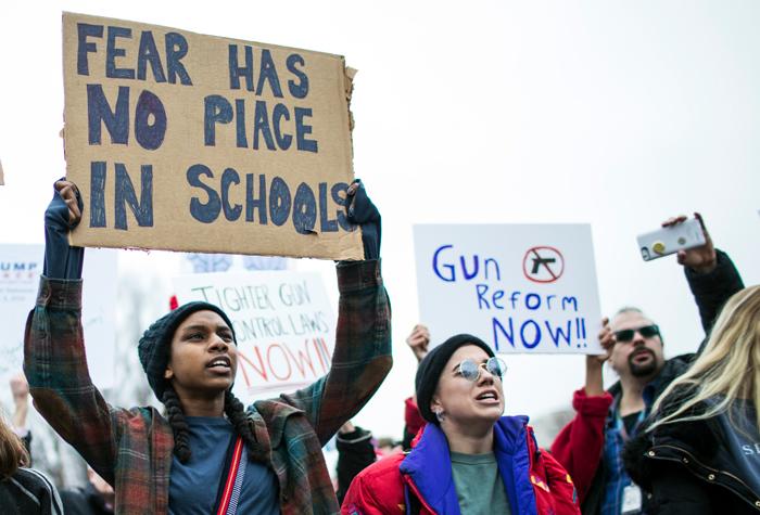 Student holding sign that reads fear has no place in schools