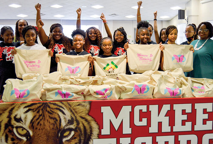 Photo of young Black girls holding Women in Training products.